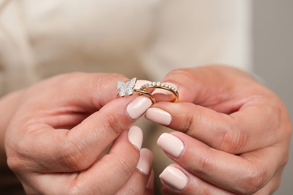buttefly diamond and band rings being held by woman