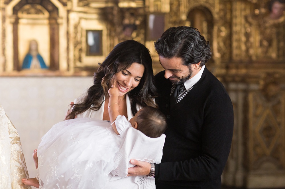 parent with their child at the baptism giving heirloom jewelry